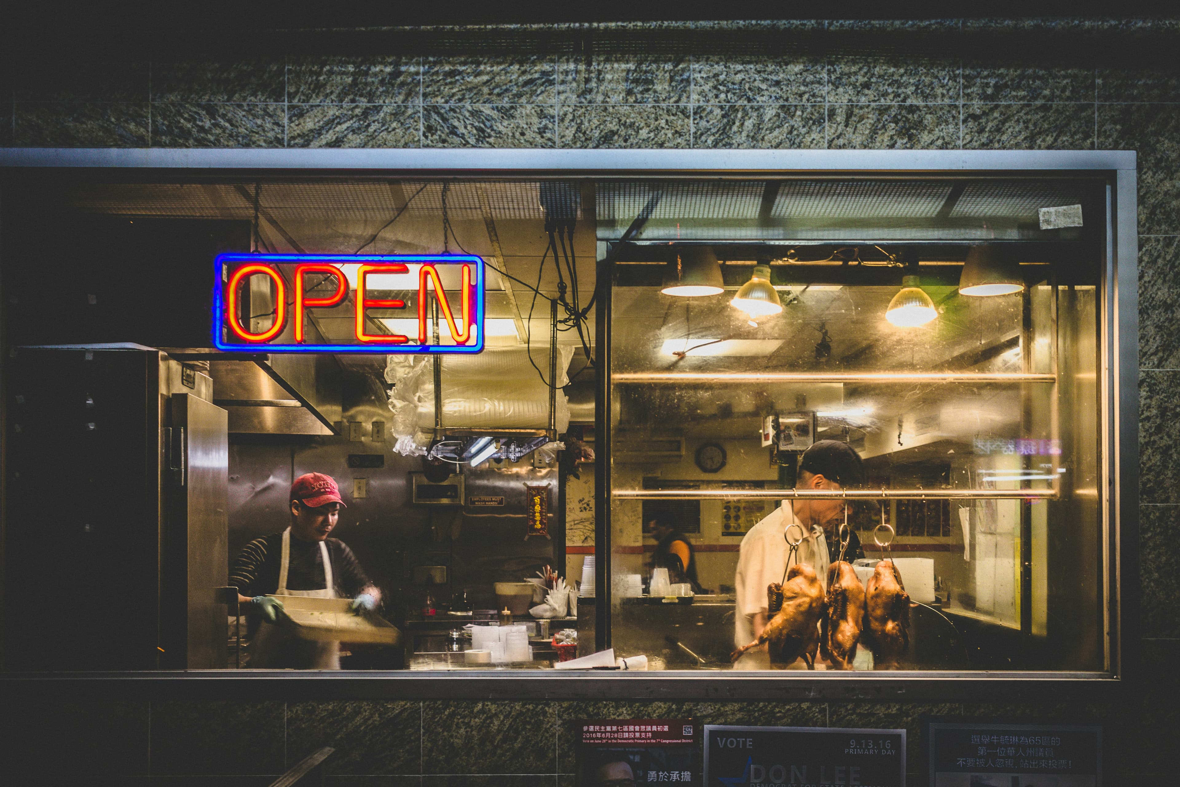 Small business restaurant kitchen at night with OPEN sign glowing